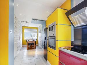 una cocina con paredes amarillas y una mesa. en Sea View Cottage, en Inverallochy