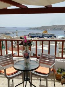 a table with a vase with flowers on a balcony at Diana in Ermoupoli