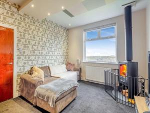 a living room with a couch and a fireplace at Sea View Cottage in Inverallochy