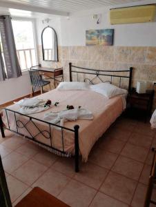 una camera da letto con un grande letto con fiori di Diana a Ermoupoli