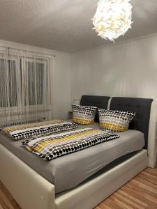 a couch in a living room with a chandelier at O&V Apartment in Waldshut-Tiengen