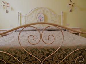 a bed with a metal bed frame with a blanket at Agriturismo Colleverde in Terricciola