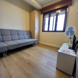 a living room with a couch and a window at Pensión Río Umia in Caldas de Reis