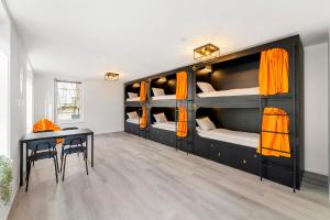 a room with bunk beds with a desk and a table at Stadtaffe - Chic Hostel VIE in Vienna