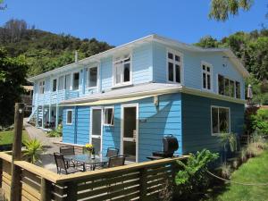 una casa azul con una mesa delante en Anakiwa 401, en Anakiwa