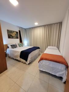 1 Schlafzimmer mit 2 Betten in einem Zimmer in der Unterkunft VILLAGE DAS ACÁCIAS NO PISCINAS NATURAIS in Mata de Sao Joao