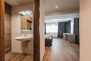 1 dormitorio y baño con lavabo. en Home NanoVid en Moviliţa-Nouă
