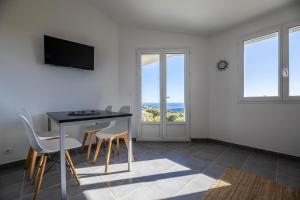 een woonkamer met een tafel en stoelen en een televisie bij Résidence Santa Monica in Bonifacio