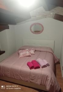 a bed with pink blankets and pillows on it at B&B Giallo Siena in Colli al Volturno
