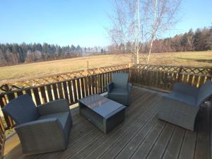 una terraza con sillas, una mesa y una valla en Rigoulotte, en Le Val-dʼAjol