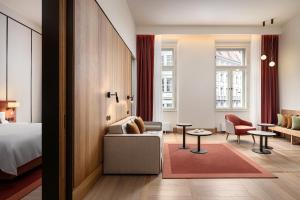 ein Hotelzimmer mit einem Bett, einem Sofa und einem Stuhl in der Unterkunft The Julius Prague in Prag