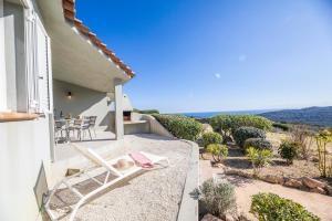 a house with a balcony with a chair and a table at Résidence Santa Monica in Bonifacio