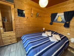 1 dormitorio con 1 cama en una habitación de madera en Superbe T3 neuf en bord de rivière près d'Annecy en Montmin