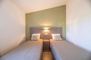 a bedroom with two beds in a room at Résidence Santa Monica in Bonifacio