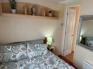 - une chambre avec un lit et un miroir dans l'établissement Toni's Family Holiday Caravan with Decking, Smart TV and Private WIFI, à Rhyl