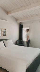 a person standing in a room with a bed at Casimiro Home in Cesena