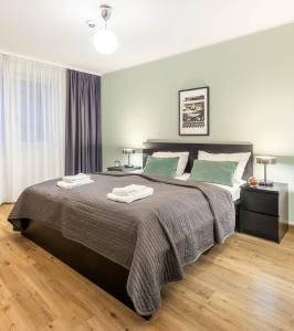ein Schlafzimmer mit einem großen Bett mit zwei Handtüchern darauf in der Unterkunft Jimmy's Apartments Lory in Wien