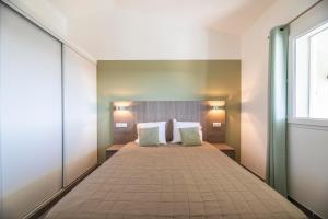 a bedroom with a large bed with two pillows at Résidence Santa Monica in Bonifacio