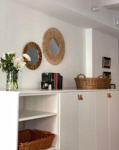a white cabinet with baskets and mirrors on the wall at Casimiro Home in Cesena