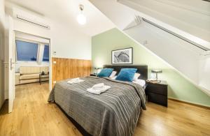 1 dormitorio con 1 cama grande con almohadas azules en Jimmy's Apartments Lory, en Viena