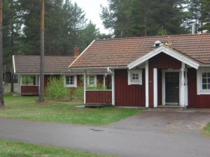 una pequeña casa roja con techo rojo en First Camp Enåbadet - Rättvik, en Rättvik