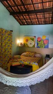 - une chambre avec un lit et des peintures murales dans l'établissement Sítio Vale da Serra, à Maranguape