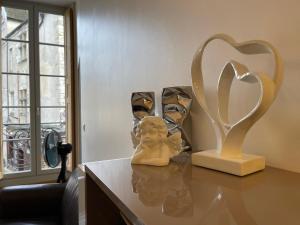ボーヌにあるLe Home Carnotの像と心臓のトロフィーが飾られたテーブル