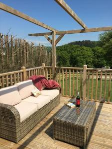 a couch and a table on a wooden deck at Unique Private Lodge in Cornwall sleeps 4 