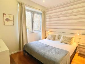 Schlafzimmer mit einem großen Bett und einem Fenster in der Unterkunft Apartments Porto Historico in Porto