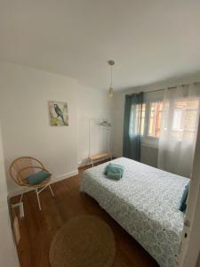 1 dormitorio con 1 cama, 1 silla y 1 ventana en Petite maison de vacances, en Fécamp