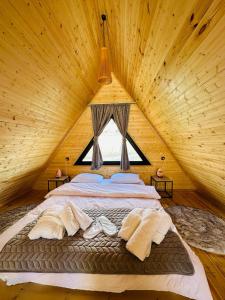 a large bed in a wooden room with a window at mood villa Kazbegi in Stepantsminda