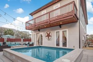a house with a swimming pool and a balcony at Sunkissed Sands in Saint Augustine
