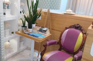 a chair sitting next to a table with books at Melody Sorrento Suites in Sorrento