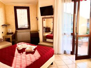 una camera d'albergo con un letto con una coperta rossa di B&B Desenzano Paradise a Desenzano del Garda