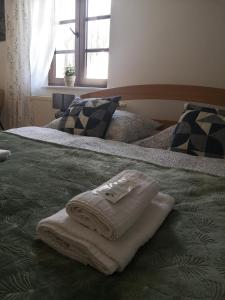 1 cama con toallas y ventana en PENZION BAŠKA VODA CZ, en Baška