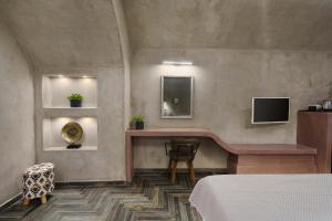 a bedroom with a bed and a tv on the wall at Elixir Del Mar on the Beach in Kamari