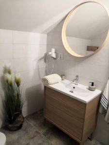 uma casa de banho com um lavatório e um espelho em PENZION BAŠKA VODA CZ em Baška