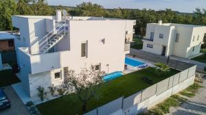 Una vista aérea de una casa blanca con piscina. en Villa Virtus, en Karigador
