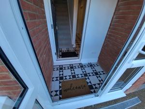 a door with a welcome sign on a tile floor at High Spec Large 6 Bedroom House! in Kingston upon Thames