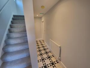 a staircase in a house with a blue carpet at High Spec Large 6 Bedroom House! in Kingston upon Thames