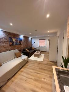 a living room with a couch and a brick wall at gemütliche Monteurwohnung,Ferienwohnung in Nörten-Hardenberg