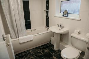 a bathroom with a sink and a toilet and a bath tub at 63 Westmorland St by Prestige Properties SA in Barrow in Furness