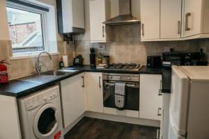 una cucina con piano cottura, lavandino e lavastoviglie di 63 Westmorland St by Prestige Properties SA a Barrow in Furness