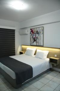 a bedroom with a large bed with white sheets at Larnaca Bay Suites in Larnaka