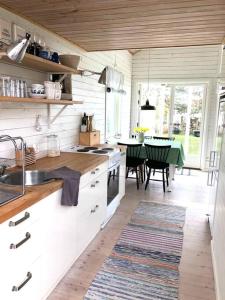 Havsnära arkitektritad stuga i Ölmanäs, Gårda brygga في Åsa: مطبخ مع دواليب بيضاء وغرفة طعام مع طاولة