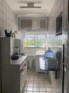 eine kleine Küche mit einem Waschbecken, einer Badewanne und einem Waschbecken in der Unterkunft Apt com vista p mar - Sea view in Guarapari