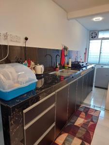 uma cozinha com um lavatório e uma bancada em Islamic Homestay Apartment Kundang, Rawang em Rawang