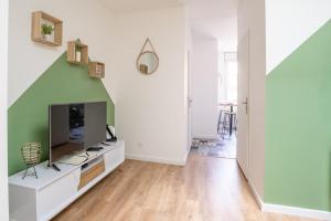 een woonkamer met een flatscreen-tv en een bank bij La Vigne Nature T2 au cœur historique de Blaye in Blaye