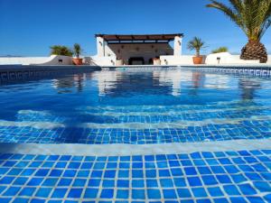 una piscina con una villa en el fondo en Villa Alta Vista, en Albox