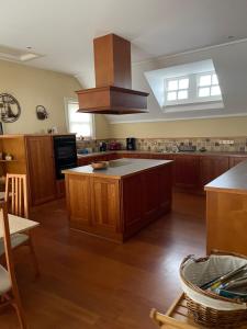 a large kitchen with wooden cabinets and a large island at Causeway Lodge in Aird